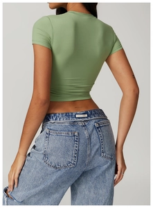 Back view of slim fit sage green crop top and distressed light blue jeans on model