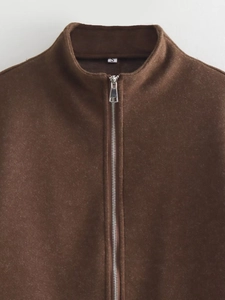 Close-up of a high-quality brown fleece jacket featuring a stand collar and silver metal zipper