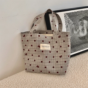 Détail du sac à lunch en toile avec pois rouges, nœuds brodés et doubles poignées
