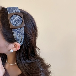 Detail of navy paisley headband with a vintage brown square buckle shown on model
