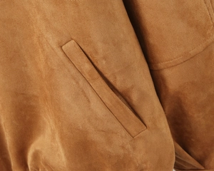 Macro detail of brown suede jacket side pocket featuring precision double stitching