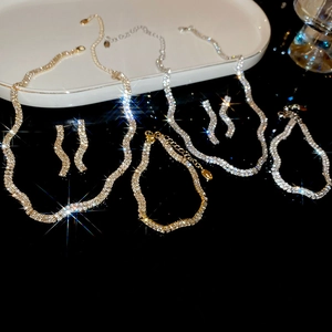 Macro shot of gold and silver twisted wave jewelry set with shimmering rhinestones