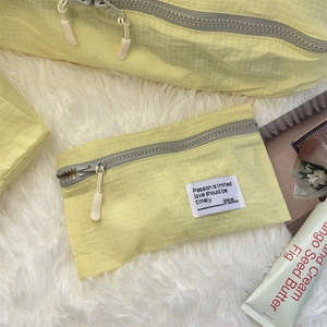 Macro shot of light yellow checkered nylon storage bags on white faux fur background