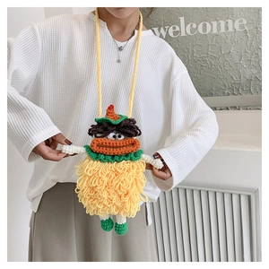Handmade crochet sausage lip bag in yellow wool with a crossbody strap shown on a model