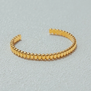 Elegant gold beaded stainless steel open bangle bracelet with a polished metallic finish