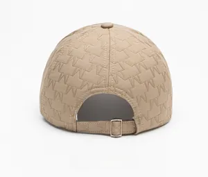 Detail view of khaki baseball cap featuring embossed M pattern and adjustable metal buckle