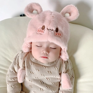 Dettaglio del cappello in peluche rosa per neonati con paraorecchie e ricami