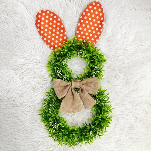 Close-up of Easter bunny wreath with green leaves, dotted ears, and burlap bow