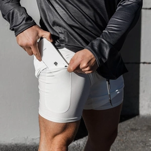 Détail du short de sport homme avec doublure de compression blanche et poche pour téléphone