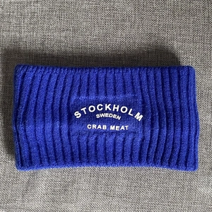 Nahaufnahme des königsblauen Rippstrick-Stirnbands mit weißem Stockholm-Schriftzug