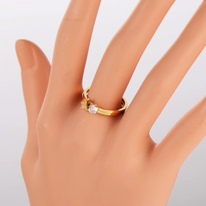 Detail of gold butterfly ring with round white zircon on a model hand mannequin