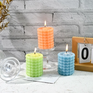 Vista dettagliata di candele profumate a colonna con motivi a bolle e cuori colorati
