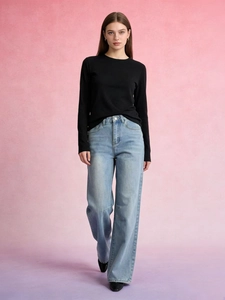 Full view of light blue wide-leg jeans paired with a black long-sleeve top on model