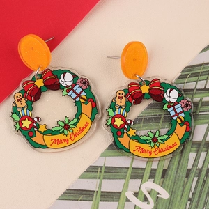 Close-up of acrylic Christmas wreath earrings with Merry Christmas lettering and festive motifs