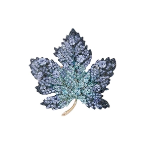 Exquisite maple leaf brooch with blue and green crystals on a gold-plated metal base