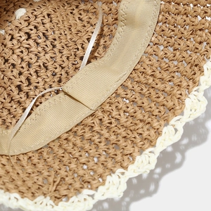 Close-up of woven straw bucket hat interior with sweatband and lace trim details