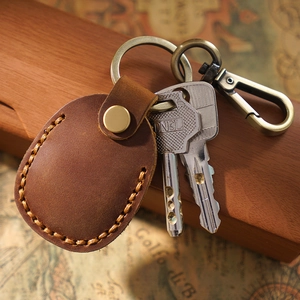 Brown genuine leather AirTag keychain with metal ring and retro map background setting