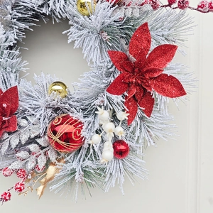 Christmas wreath with flocked pine needles, red glitter flowers, and gold ornaments