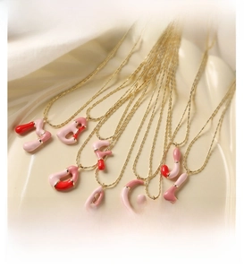 Détail de 26 pendentifs lettres en émail avec finition colorée rose et crème huilée