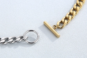 Macro detail of OT toggle clasp in gold and silver mixed tones on stainless steel necklace