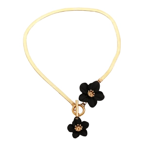 Detail of gold snake chain necklace with black flower pendants and toggle clasp