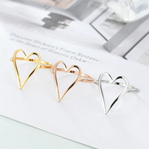 Detailed view of three open heart rings in gold, rose gold, and silver finishes