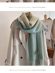 Detail of mint green wool scarf with soft fringes styled on a cream double-breasted coat