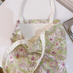 Vista dettagliata di una borsa tote in tela a fiori primaverili con manici beige