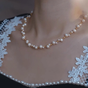 Close-up of elegant double-layer pearl necklace featuring baroque pearls and gold beads