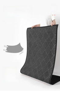 Detail of durable dark gray polypropylene doormat with non-slip rubber backing and woven texture