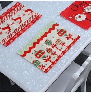 Detail of Christmas placemats featuring reindeer and Santa Claus prints on festive fabric