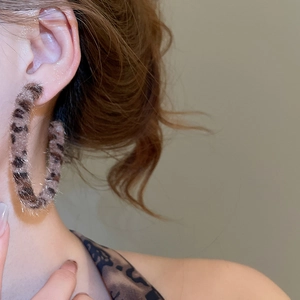 Close-up of leopard print plush hoop earrings with vintage brown faux fur texture