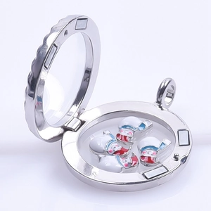 Macro shot of silver locket featuring enamel snowmen charms and metallic finish details