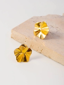 Detailed close-up of gold-plated petal earrings with a polished mirror finish on stone