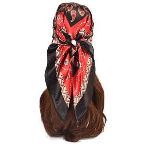 Detail of red and black paisley satin scarf tied elegantly on a model with white background