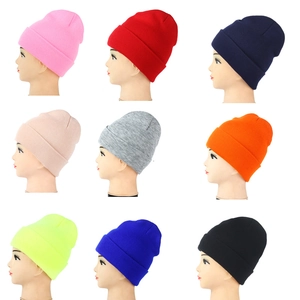 Detail showing nine solid color knitted beanies with classic cuffed design for adults
