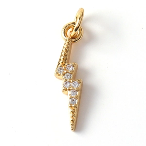 Macro shot of gold-plated lightning bolt charm with sparkling crystal zircon stones