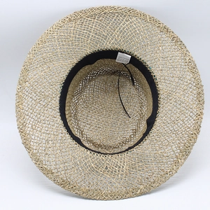 Close-up of woven straw sun hat with 100% paper material label and sweatband detail