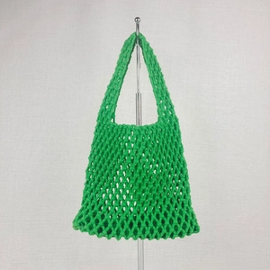 Close-up of grass green woven mesh tote bag with thick cotton rope diamond pattern