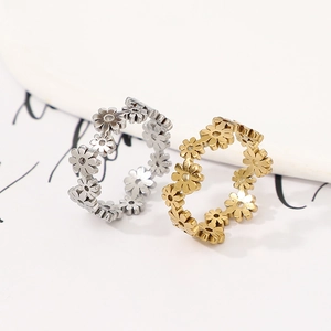 Macro view showing detailed daisy floral engraving on gold and silver titanium rings