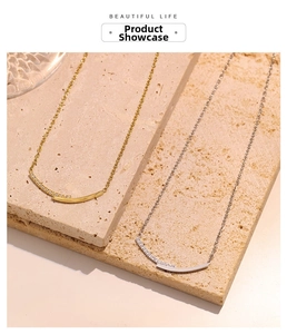 Detail of gold and silver layered smile necklaces with zircon pavé on travertine stone
