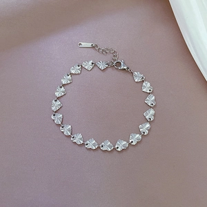 Close-up of heart-shaped link bracelet in silver stainless steel with sunburst texture