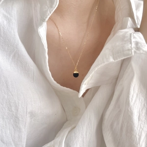 Minimalist 925 silver necklace with black agate pendant worn on a white shirt model