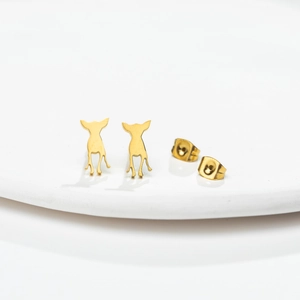 Minimalist gold stainless steel puppy silhouette stud earrings on a white tray