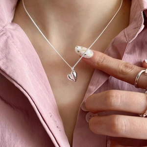 Polished 925 sterling silver heart pendant necklace for women on a pink background