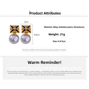 Detail of vintage earrings with gold star pattern, rhinestones and large white pearls