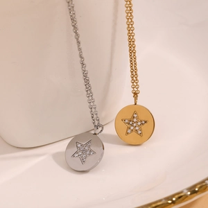 Gros plan de pendentifs ronds plaqués or 18 carats et argent avec étoiles serties