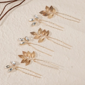 Détail de 6 épingles à cheveux en U avec feuilles dorées et strass en vue diagonale précise