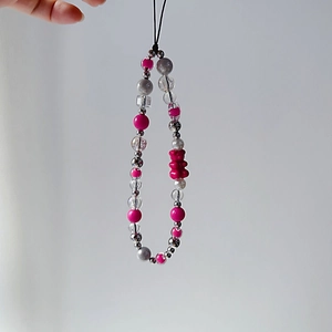 Detail of beaded phone strap with pink bear charm and assorted pearl-like beads