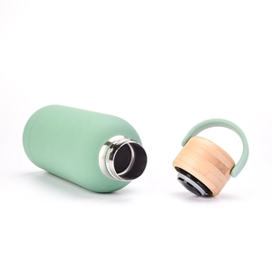 Macro view of mint green 350ml insulated bottle with stainless steel interior and bamboo lid